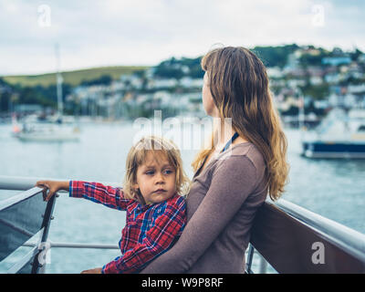 Une jeune mère et son enfant sont assis sur un bateau dans le port Banque D'Images