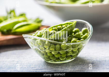 Les graines de pois verts frais dans un bol sur une table de cuisine Banque D'Images