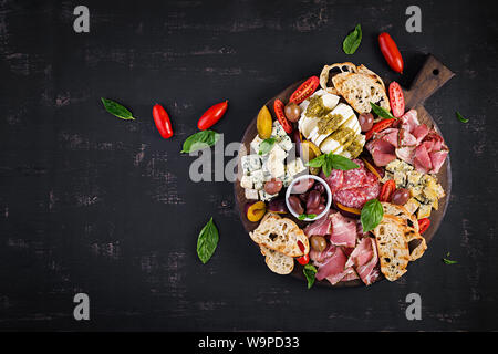 L'antipasto platter avec jambon, jambon, salami, fromage bleu, mozzarella au pesto et olives sur un fond de bois. Vue de dessus, les frais généraux Banque D'Images