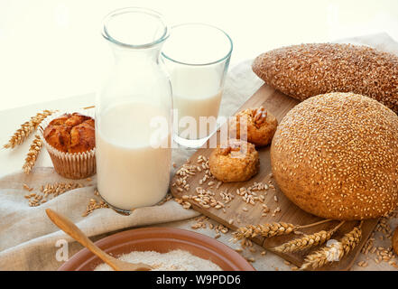 Still Life de lait, pain, biscuits, petits gâteaux, une assiette de son, d'épillets d'orthographié et poldba dispersés de grains. Il est tous sur le chanvre et tissu sur un wh Banque D'Images