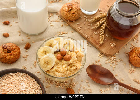 Gruau d'épeautre avec des tranches de banane et d'amandes dans un bol en verre. Banque D'Images