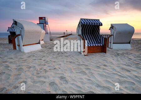 Lever du soleil sur la côte de la mer Baltique,la chaise de plage se trouve sur la plage de sable. Banque D'Images