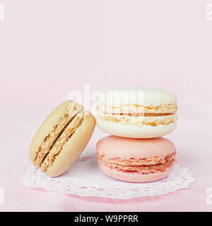 Plusieurs macarons multicolores couleurs pastel sur fond rose Banque D'Images