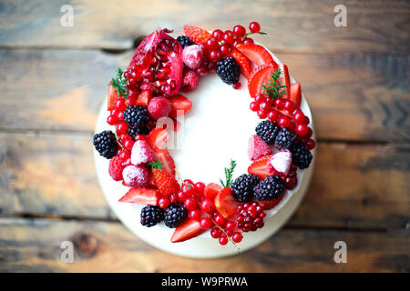 Gâteau décoré de Noël aux fruits rouges sur la table rustique en bois Banque D'Images