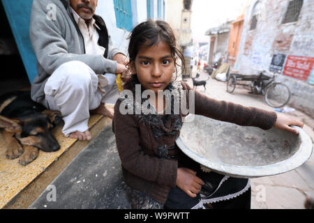 Girl porte un bol dans les rues de Varanasi à Varanasi, Inde. Varanasi est le plus saint des sept villes sacrées de l'Inde. Banque D'Images