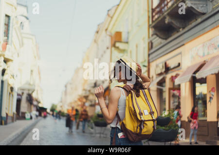 Vue arrière d'une jeune femme avec un sac à dos sur son épaule en excursion dans une ville étrangère, femme élégante architecture étranger examine Banque D'Images