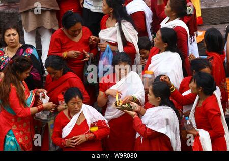 Katmandou, Népal. Août 15, 2019. Les femmes offrent des prières durant le Janai Purnima festival au temple de Pashupatinath à Katmandou, Népal, le 15 août, 2019. Pendant ce festival, les Hindous prendre bain saint et effectuer le changement annuel de la Janai, une chaîne de coton sacré porte autour de la poitrine ou attaché au poignet, dans la conviction qu'il n'accordera de protection et les purifier. Credit : Sunil Sharma/Xinhua Banque D'Images