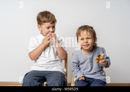 Les enfants à l'intérieur de manger des pizzas, d'être malheureux. Mauvais piza le moment. Pizza avec un ananas. Banque D'Images