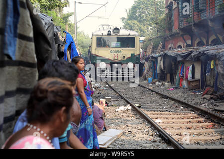 Les gens regardent le train dans un bidonville à Kolkata, Inde Banque D'Images