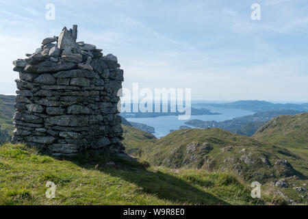 Cairn le long de la Vidden randonnée entre le mont Ulriken et Mount Fløyen à Bergen, Norvège, Scandinavie avec Askøy island dans l'arrière-plan Banque D'Images