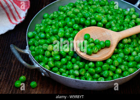 Aufgetaute gruene Erbsen Kochloeffel de Schale mit, Pisum sativum Banque D'Images