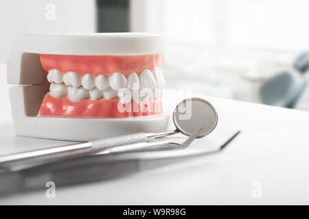 Modèle de dent et d'outils de dentiste sur la table en bureau de dentiste Banque D'Images