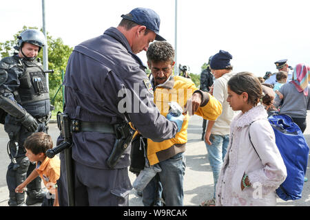 Bregana, la Slovénie - 20 septembre 2015 : La police contrôle de réfugiés syriens à la frontière slovène avec la Croatie. Les migrants sont en attente de l'ua Banque D'Images