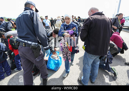 Bregana, la Slovénie - 20 septembre 2015 : La police contrôle de réfugiés syriens à la frontière slovène avec la Croatie. Les migrants sont en attente de l'ua Banque D'Images