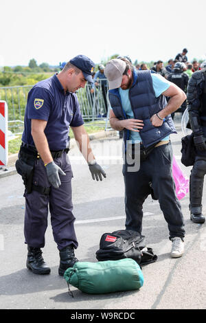 Bregana, la Slovénie - 20 septembre 2015 : La police contrôle de réfugiés syriens à la frontière slovène avec la Croatie. Les migrants sont en attente de l'ua Banque D'Images
