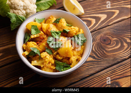 Aloo Gobi. Cuisine indienne curry végétarien cuisiné avec des pommes de terre, chou-fleur, le gingembre, l'ail et les épices - cumin, coriandre, piment et garam masala. brow Banque D'Images