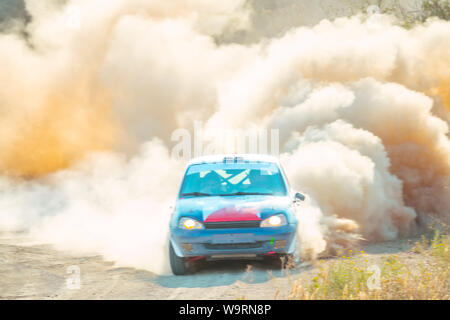 Journée ensoleillée d'été. Voiture de rallye et tourner sur une route poussiéreuse Banque D'Images