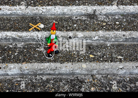 Marionnette pinocchio en bois sur un grunge des escaliers. Marionnette jouet rétro Banque D'Images