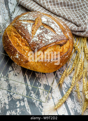 Un tir vertical d'un délicieux pain au levain fraîchement cuits sur une plaque de cuisson sur le fil. Banque D'Images