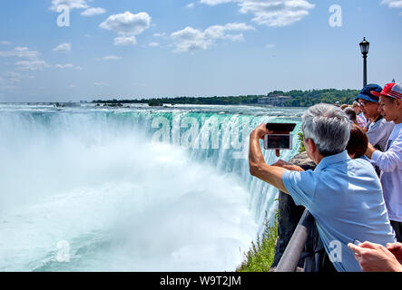 NIAGARA FALLS, CANADA - 25 juillet 2019 : Les gens qui prennent plus de selfies Chutes du Niagara sur une belle journée ensoleillée. Point de vue canadien. Niagara Falls a trois Banque D'Images