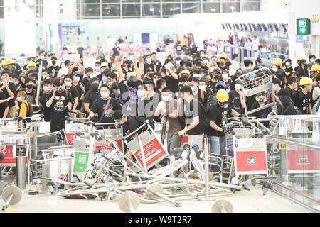 (190815) -- HONG KONG, 15 août 2019 (Xinhua) -- les radicaux violents bloquer un passage à l'Aéroport International de Hong Kong dans le sud de la Chine, Hong Kong, le 13 août 2019. Deux mois plus tard, l'escalade de la violence à Hong Kong a eu de lourdes conséquences sur l'ordre social. Radicaux violents commis des actes de vandalisme, de voies de circulation principale bloqué, harcelé les navetteurs urbains et mis le feu à volonté. Beaucoup ont appelé à un frein pour être mis sur la violence flagrante et pour pouvoir être restauré. (Xinhua) Banque D'Images