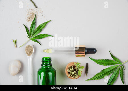 Pipette en verre bouteille verte et avec la CDB et de l'huile de feuille de cannabis sur l'arrière-plan. Concept minimal. Mise à plat. Banque D'Images