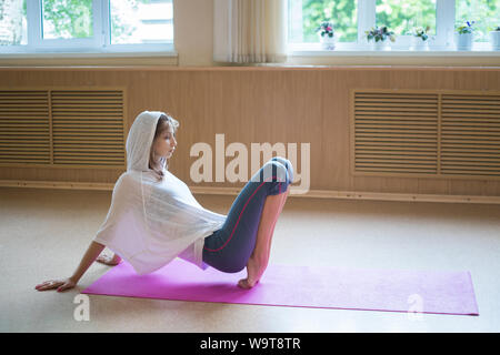 Jeune femme ballerine est sur sa pointe des pieds sur le tapis de yoga - studio de danse Banque D'Images