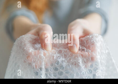 Femmes popping les bulles dans l'enveloppe de bulle. Selective focus, Close up. Banque D'Images