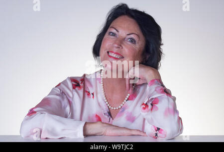 Studio shot of a beautiful young woman looking at camera sur un fond uni - John Gollop Banque D'Images