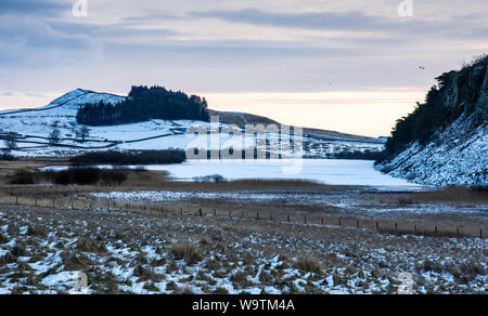 Neige de l'hiver se trouve sur le domaine de l'Hotbank le lac gelé à côté de la ferme de Crag Lough le long mur d'Hadrien, dans le Northumberland. Banque D'Images