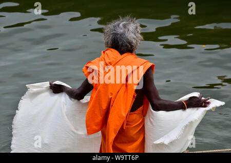 Vieil indien homme habillé en orange sur les rives du Gange, à Varanasi, Inde Banque D'Images