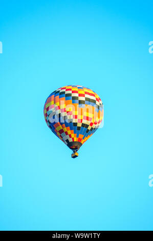 Montgolfière colorée décollant avec ciel bleu Banque D'Images