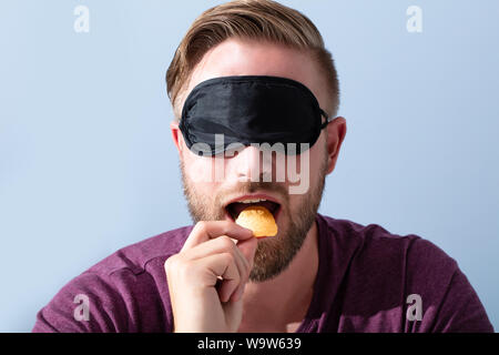 Portrait de jeune homme, les yeux bandés, nourriture d'échantillon Banque D'Images