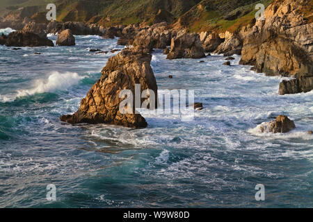 Dernière lumière sur le fracas des vagues contre les piles de la mer et du littoral à Garrapata State Park le long de la côte de Monterey en Californie. Banque D'Images