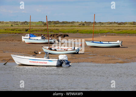 Le bateau du capitaine de port et d'autres bateaux bloqués à Brancaster Staithe, sur la côte nord du comté de Norfolk, à marée basse Banque D'Images