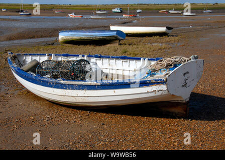 Les petits bateaux échoués sur la plage à Brancaster Staithe, sur la côte nord du comté de Norfolk, à marée basse Banque D'Images