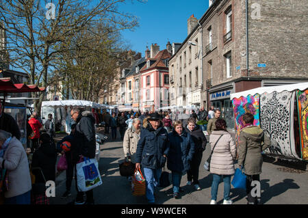 Shoppers marche à travers le marché de rue dans le centre de Dieppe, en France, le froid d'un matin de printemps. Banque D'Images