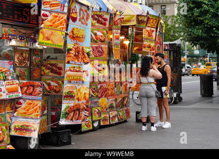 New York City, NY / USA - Le 28 juin 2019 : l'homme et la femme l'achat de nourriture à un vendeur de rue en face de la Met Banque D'Images