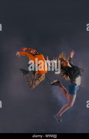 Couple de danse a sauté en l'air élevé tout en effectuant le même mouvement de danse. Banque D'Images