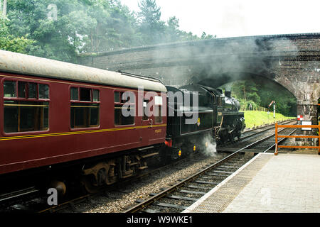 Aucune locomotive 76084 class 4MT, il roule sous le pont à Weybourne gare avec un râteau de calèches Banque D'Images