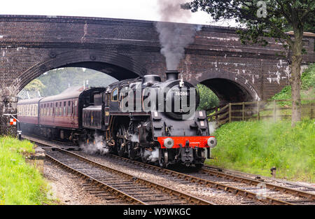 Aucune locomotive 76084 class 4MT, il roule sous le pont à Weybourne gare avec un râteau de calèches Banque D'Images