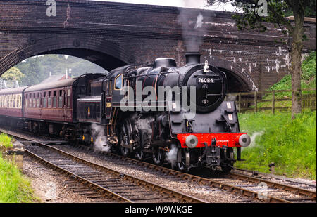 Aucune locomotive 76084 class 4MT, il roule sous le pont à Weybourne gare avec un râteau de calèches Banque D'Images