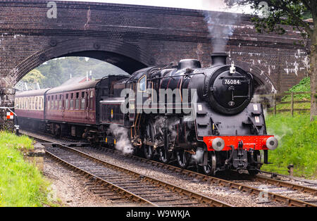 Aucune locomotive 76084 class 4MT, il roule sous le pont à Weybourne gare avec un râteau de calèches Banque D'Images