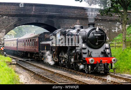 Aucune locomotive 76084 class 4MT, il roule sous le pont à Weybourne gare avec un râteau de calèches Banque D'Images