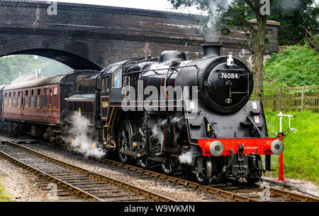Aucune locomotive 76084 class 4MT, il roule sous le pont à Weybourne gare avec un râteau de calèches Banque D'Images