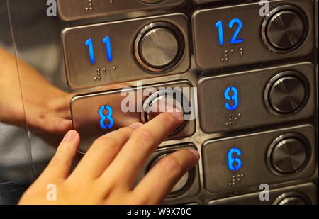 Montréal, Québec / Canada - Juillet 24, 2019 : part tend la main pour appuyer sur un bouton d'ascenseur Banque D'Images