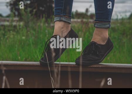 Gros plan extrême d'une personne portant des sneakers basses noires avec lacets Banque D'Images