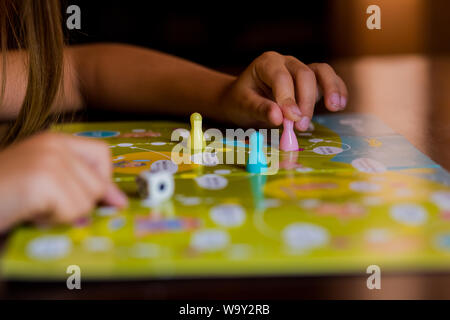 Multi-couleur jetons de jeu avec des dés sur le conseil de jeu. Jeu de société.Les enfants sont assis dans le jardin d'enfants à la table principale est, apprendre à la pépinière,lecture Banque D'Images