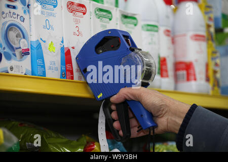 Buenos Aires, Argentine. 14Th Aug 2019. Un employé le marque packs de lait avec de nouveaux prix après cette semaine de la crise économique. Les marchés boursiers à Buenos Aires se sont effondrées à la suite de la défaite électorale pour le président Macri's gouvernement libéral dans les élections primaires. L'indice S&P Merval a perdu 35,5  %. Le peso argentin a également battu dans. En conséquence, les prix ont augmenté dans plusieurs secteurs. L'Argentine est dans une grave récession, avec 10,1  % de chômage et plus de 50 pour cent de l'inflation. Credit : Claudio Santisteban/dpa/Alamy Live News Banque D'Images