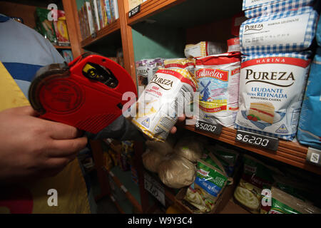 Buenos Aires, Argentine. 14Th Aug 2019. Un employé de la farine avec de nouveaux packs marques prix après cette semaine de la crise économique. Les marchés boursiers à Buenos Aires se sont effondrées à la suite de la défaite électorale pour le président Macri's gouvernement libéral dans les élections primaires. L'indice S&P Merval a perdu 35,5  %. Le peso argentin a également battu dans. En conséquence, les prix ont augmenté dans plusieurs secteurs. L'Argentine est dans une grave récession, avec 10,1  % de chômage et plus de 50 pour cent de l'inflation. Credit : Claudio Santisteban/dpa/Alamy Live News Banque D'Images